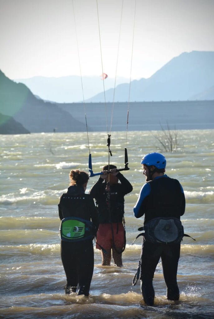 Clase grupal de kitesurf en Embalse Puclaro: alumnos e instructor practicando con la barra en el agua