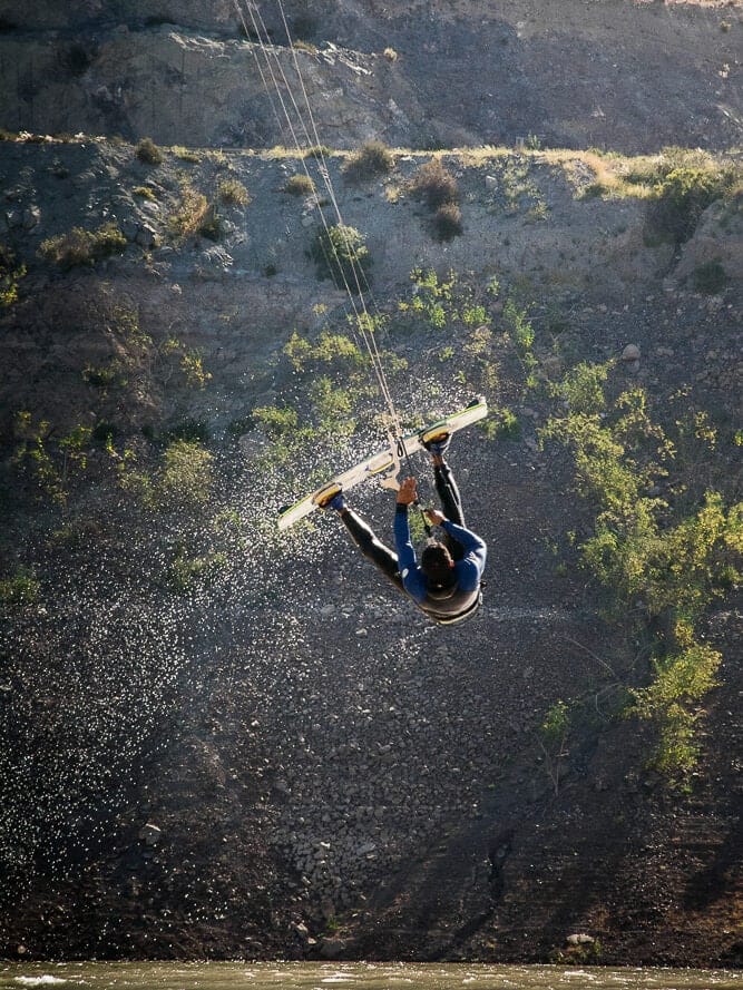 Instructor performing an inverted boogie loop during advanced kitesurf lessons at Puclaro Reservoir, Chile.