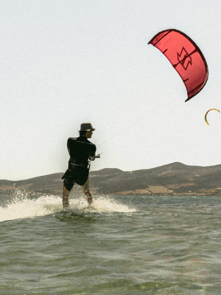 Rider de kitesurf navegando con cometa sobre el agua en el Embalse Puclaro, Valle del Elqui