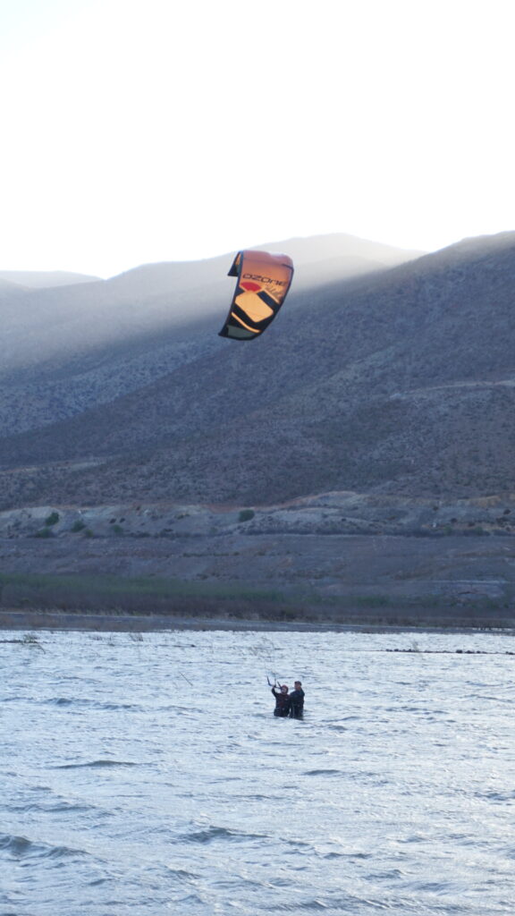 Alumno principiante en una clase privada de kitesurf uno a uno con la escuela Puclaro Kitesurfing en el embalse con instructor certificado IKO.
