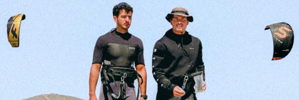 Dos instructores de kitesurf con traje y arnés caminando por la orilla del Embalse Puclaro