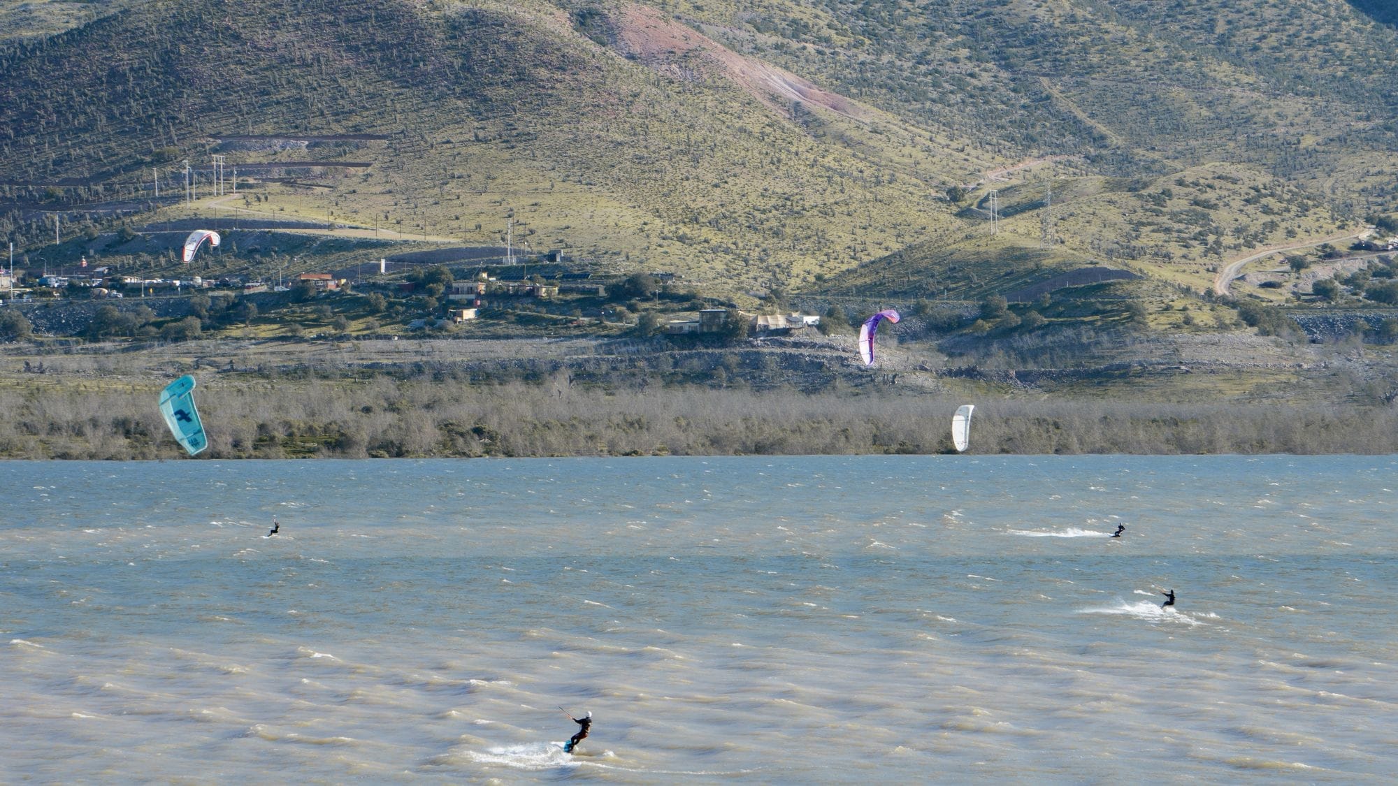 Cuatro riders navegando en kitesurf en el Embalse Puclaro, Valle de Elqui