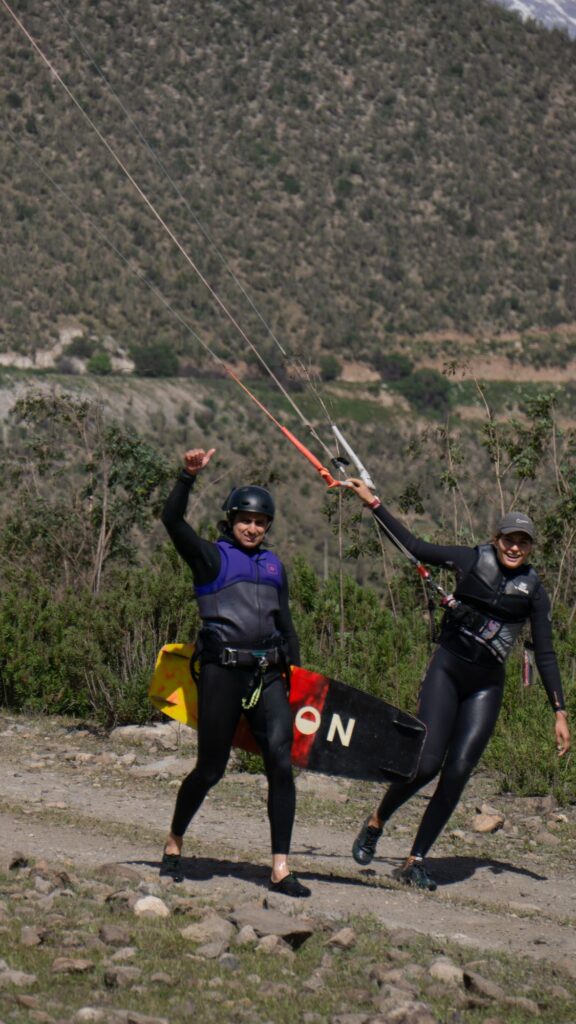 Instructora y alumna felices con el kite en el aire durante una clase privada en Puclaro