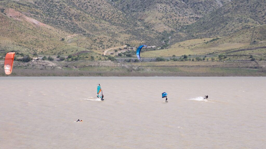 Varios riders navegando en el spot del Embalse Puclaro con los cerros del Valle de Elqui